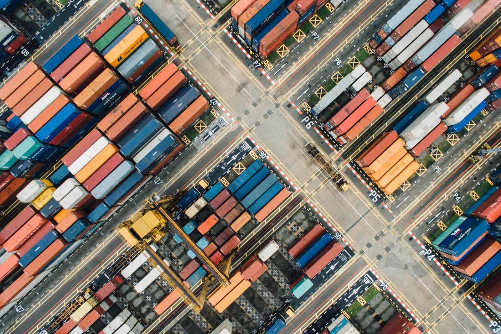 A container yard photographed from directly above, stacks arranged in numbered lanes.